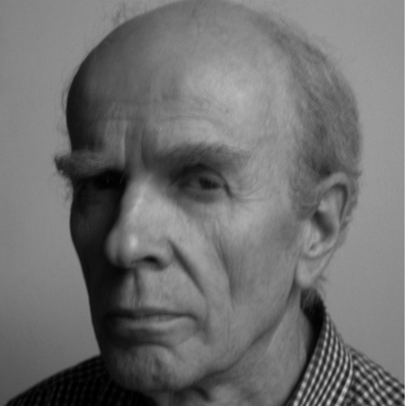 Svartvitt närbildsporträtt av man med ett allvarligt uttryck.