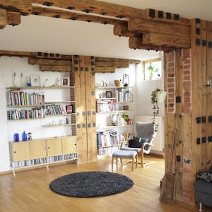Ett vardagsrum med träbjälkar.