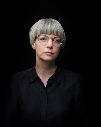 En kvinna som bär glasögon och en svart skjorta.