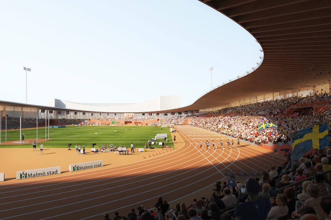 En stor publik tittar på en friidrottstävling på ett utomhusstadion där idrottare springer på banan och flaggor syns på läktarna.