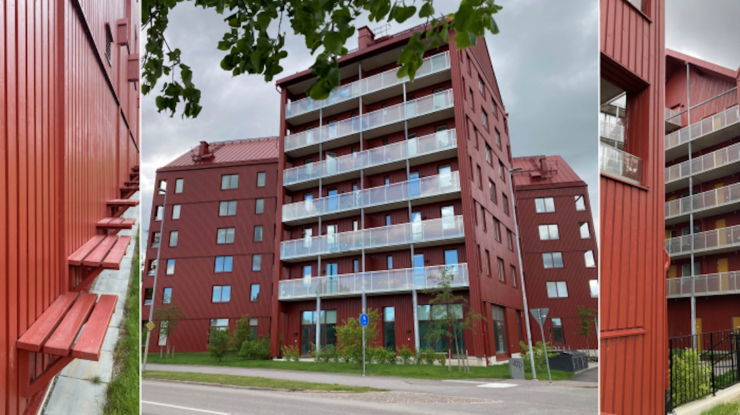 Flerbostadshus med flera våningar i röd färg, glasbalkonger och tak av metall, omgiven av växtlighet. Byggnaden ses från olika håll under en molntäckt himmel.