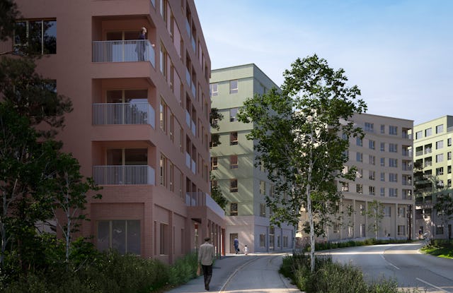 En person går på en gångväg bredvid flerbostadshus med balkonger och träd runtom.