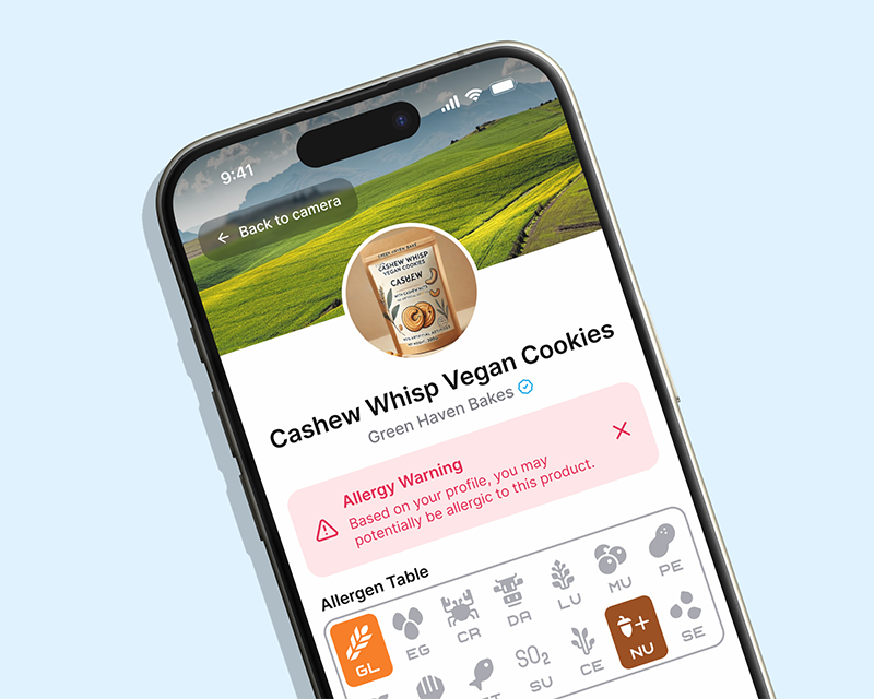 En smartphoneskärm visar en produktsida för Cashew Whisp Vegan Cookies med allergivarning och tabell över allergener.