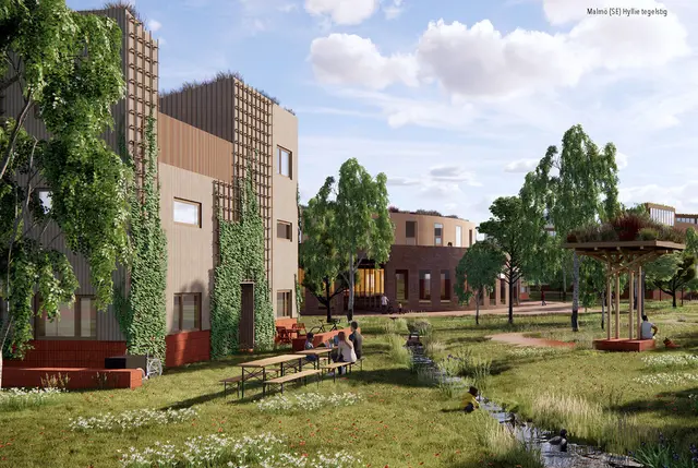 Bostadshus med växter på fasaderna, personer vid picknickbord, en bäck och ett ordnat uteområde under delvis molnig himmel.