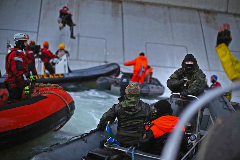 Rysk kustbevakning pekar med ett vapen mot Greenpeace-aktivister. Foto: Greenpeace