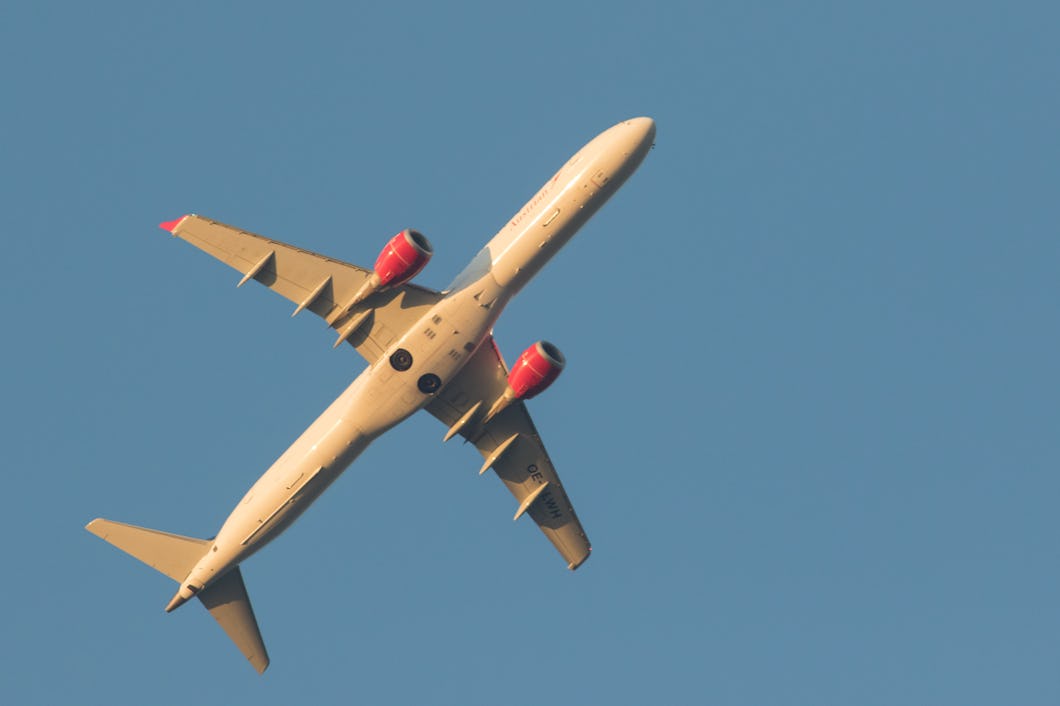 Ett stort flygplan som flyger genom en klarblå himmel.