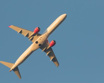 Ett stort flygplan som flyger genom en klarblå himmel.