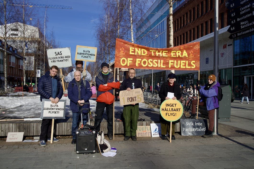 Grupp aktivister som håller banderoller för att protestera mot fossila bränslen och förespråka miljöförändringar.