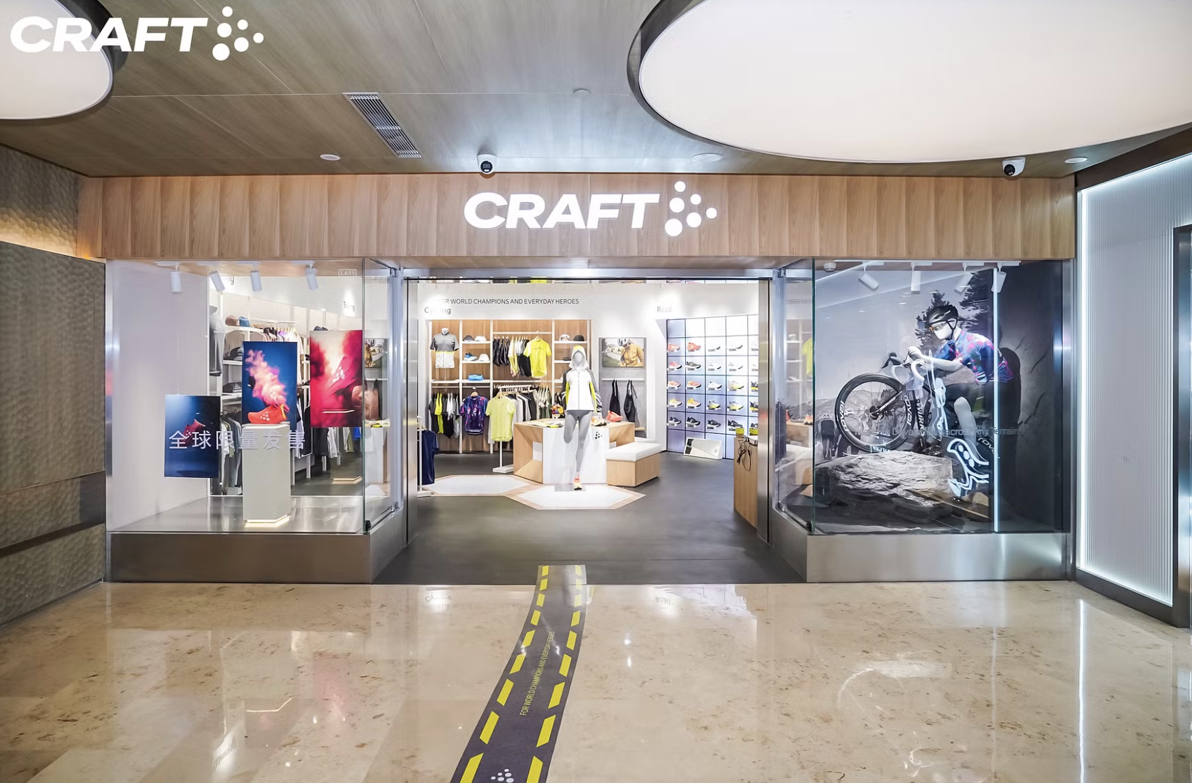 Butikens entré till en CRAFT sportklädesaffär syns från en gång i gallerian. Skyltdockor, kläder och affischer på idrottare är uppställda i skyltfönstret.